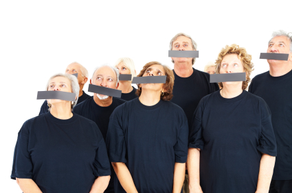 Group of elderly people with their mouths covered, looking up at