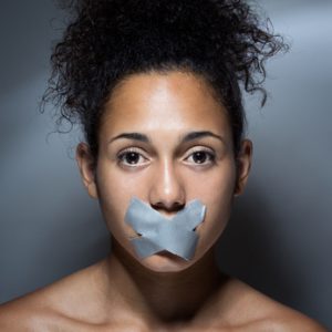 black woman with mouth covered with tape
